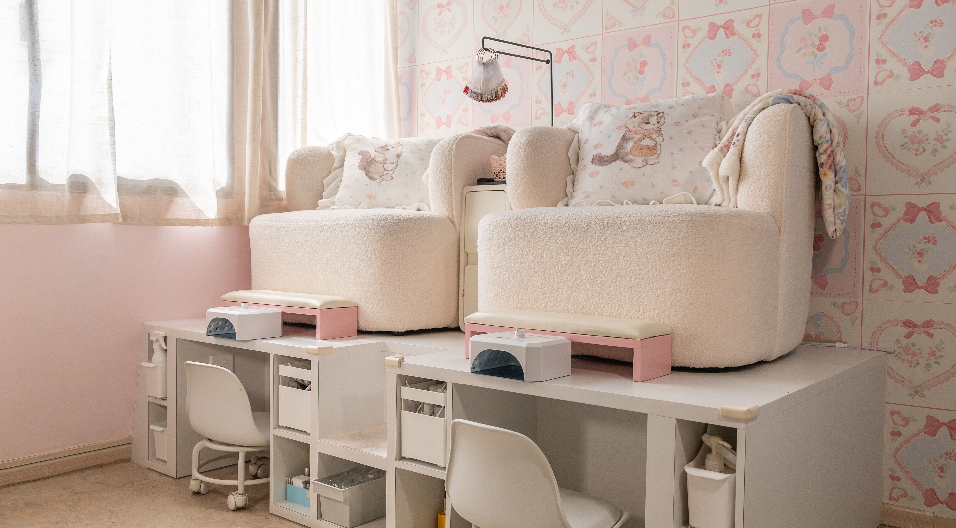 Comfortable seating area at FNF NAIL ARTISTRY, Singapore, SG with plush chairs and pastel decor.