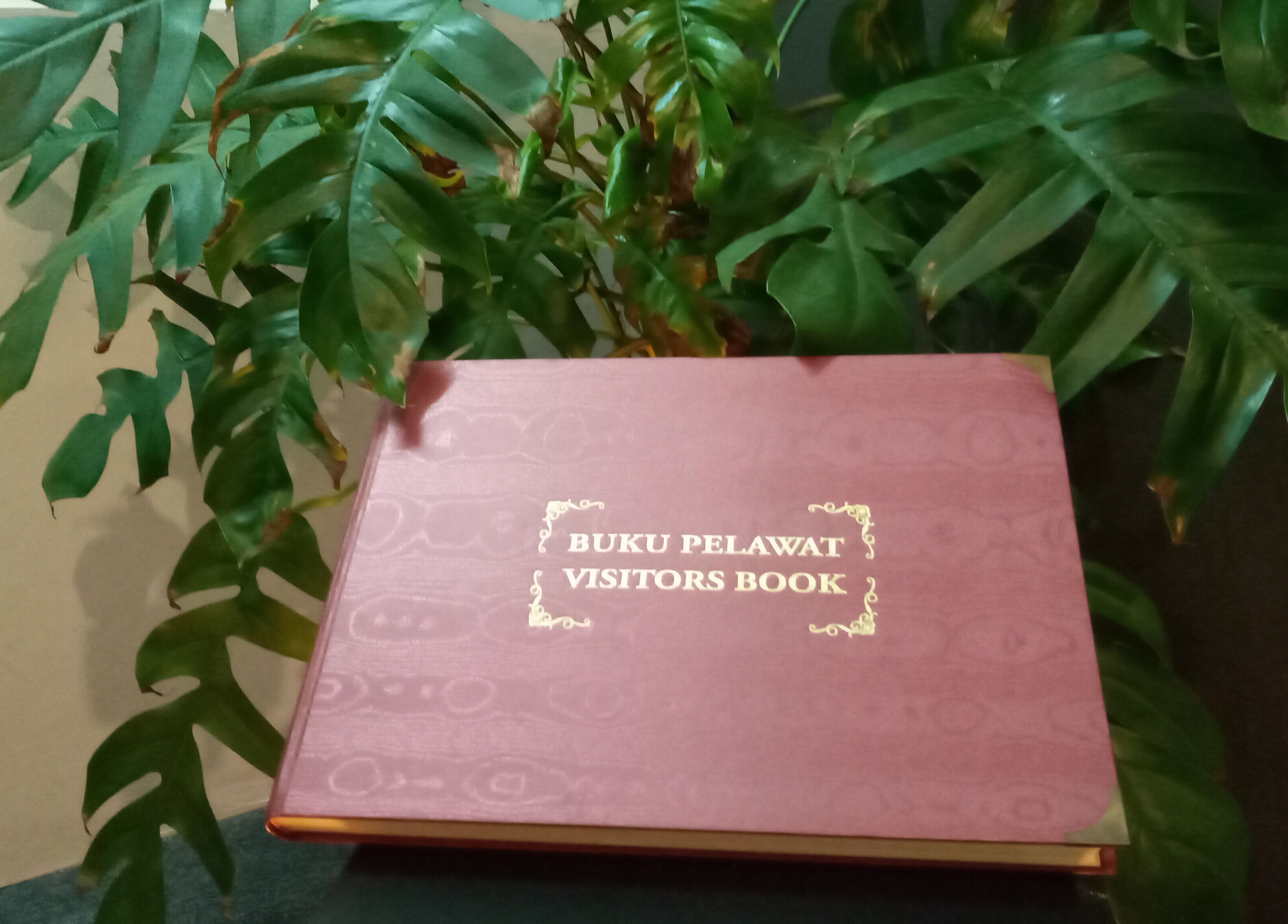 Visitors book at Family First Consultancy, Petaling Jaya, Selangor, MY, surrounded by lush green plants.
