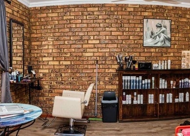 Cozy salon interior at Hair@Lerina in Centurion, Gauteng, ZA with brick walls and stylish seating.