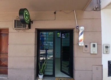 Entrada de Simón B 402 en San Miguel De Tucumán, Tucumán, AR, con puerta de vidrio y cartel de barbería.