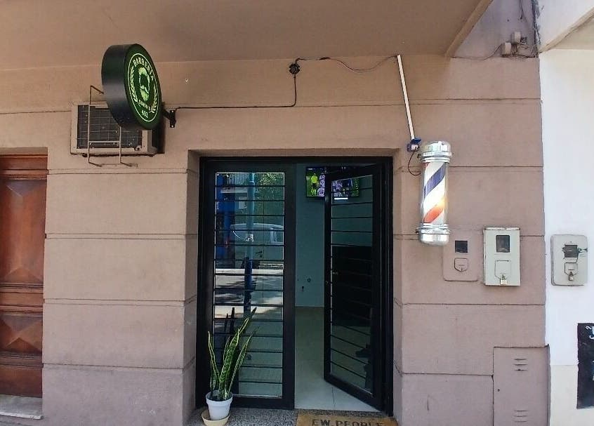 Entrada de Simón B 402 en San Miguel De Tucumán, Tucumán, AR, con puerta de vidrio y cartel de barbería.