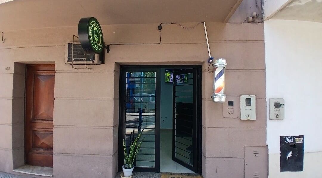 Entrada de Simón B 402 en San Miguel De Tucumán, Tucumán, AR, con puerta de vidrio y cartel de barbería.