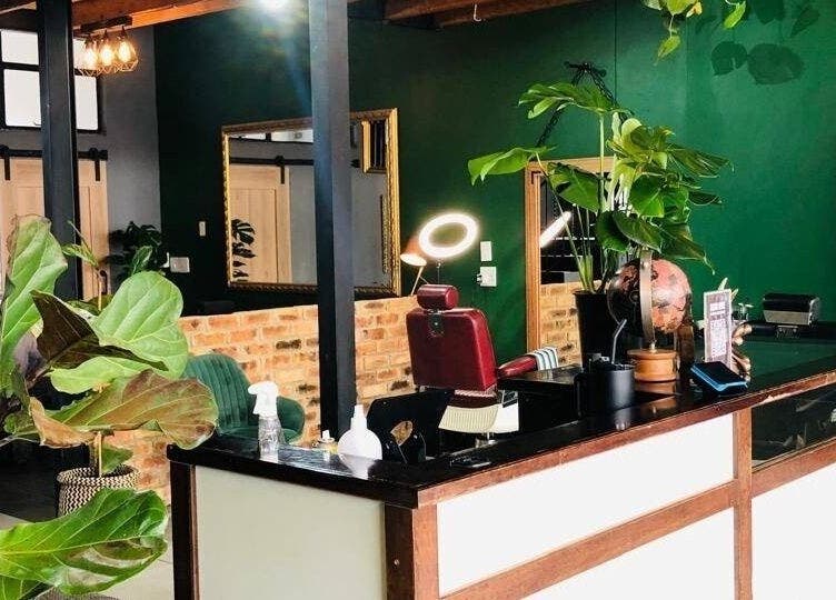 Interior of Mike Hairstylist / Barber in Sandton, Gauteng, ZA with green decor and stylish seating.