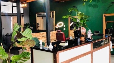 Interior of Mike Hairstylist / Barber in Sandton, Gauteng, ZA with green decor and stylish seating.