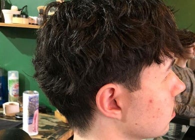 Client with fresh haircut at Mike Hairstylist / Barber in Sandton, Gauteng, ZA. Modern salon decor visible.