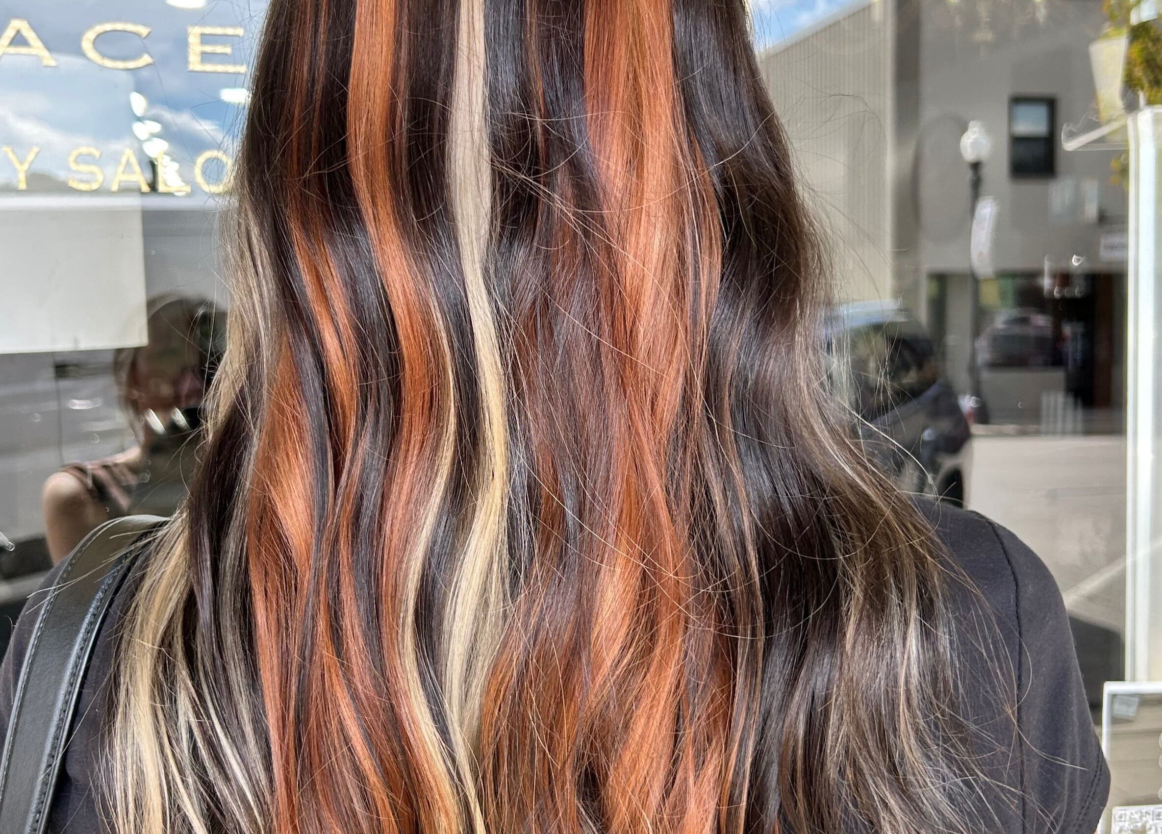 Vibrant hair coloring at Danielle Chew salon in Atchison, Kansas, US, showcasing stylish multicolor waves.