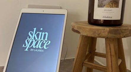 Skin Space by Lauren, Worsley, features an inviting spa setup with digital logo and scented candle.