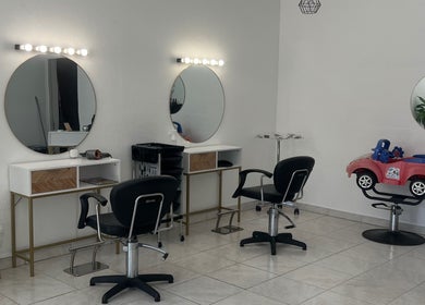 Interior moderno do Cabeleireiro Vera em Portimão, Faro, PT, com cadeiras e espelhos elegantes.
