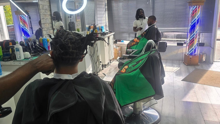 Stylists at work inside Ob's Barbers, Nottingham, England, GB, enhancing client looks with attention.