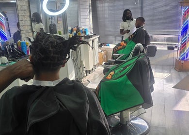 Stylists at work inside Ob's Barbers, Nottingham, England, GB, enhancing client looks with attention.