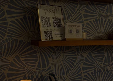 QR codes for social media on a shelf at The Daily Glow LLC in Tuscaloosa, Alabama, US.