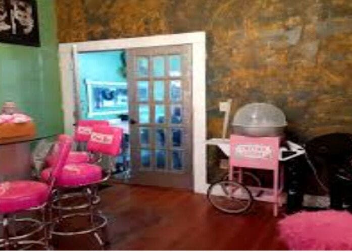 Bright interior of Kbstyles in Jonesboro, Georgia, US with pink chairs and stylish decor.