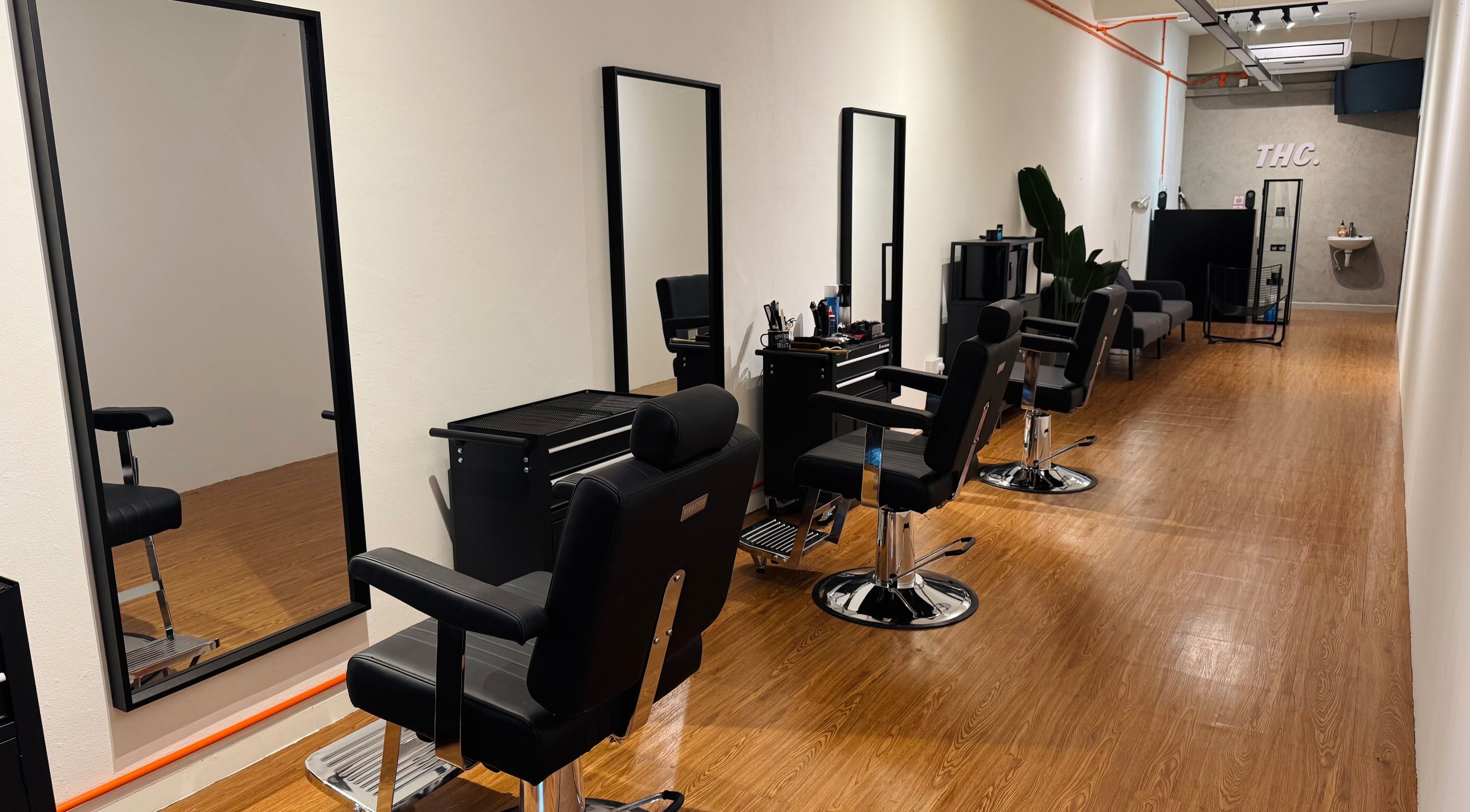 Stylish interior of The Hair Culture Barber Studio, Johor Bahru, Johor Darul Ta'zim, MY, with sleek chairs and mirrors.