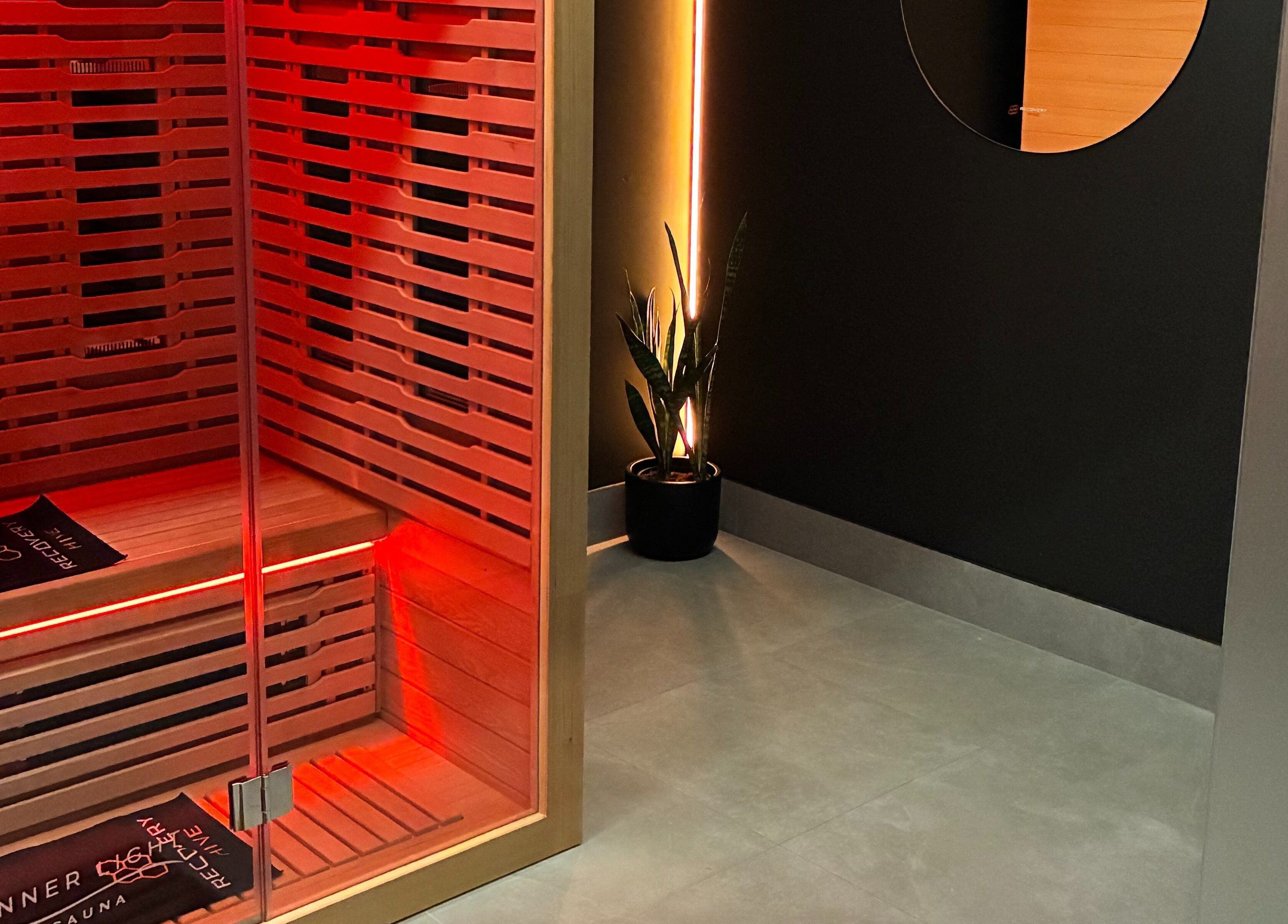 Red-lit sauna room at Recovery Hive, Coolum Beach, Queensland, AU offering relaxation and tranquility.