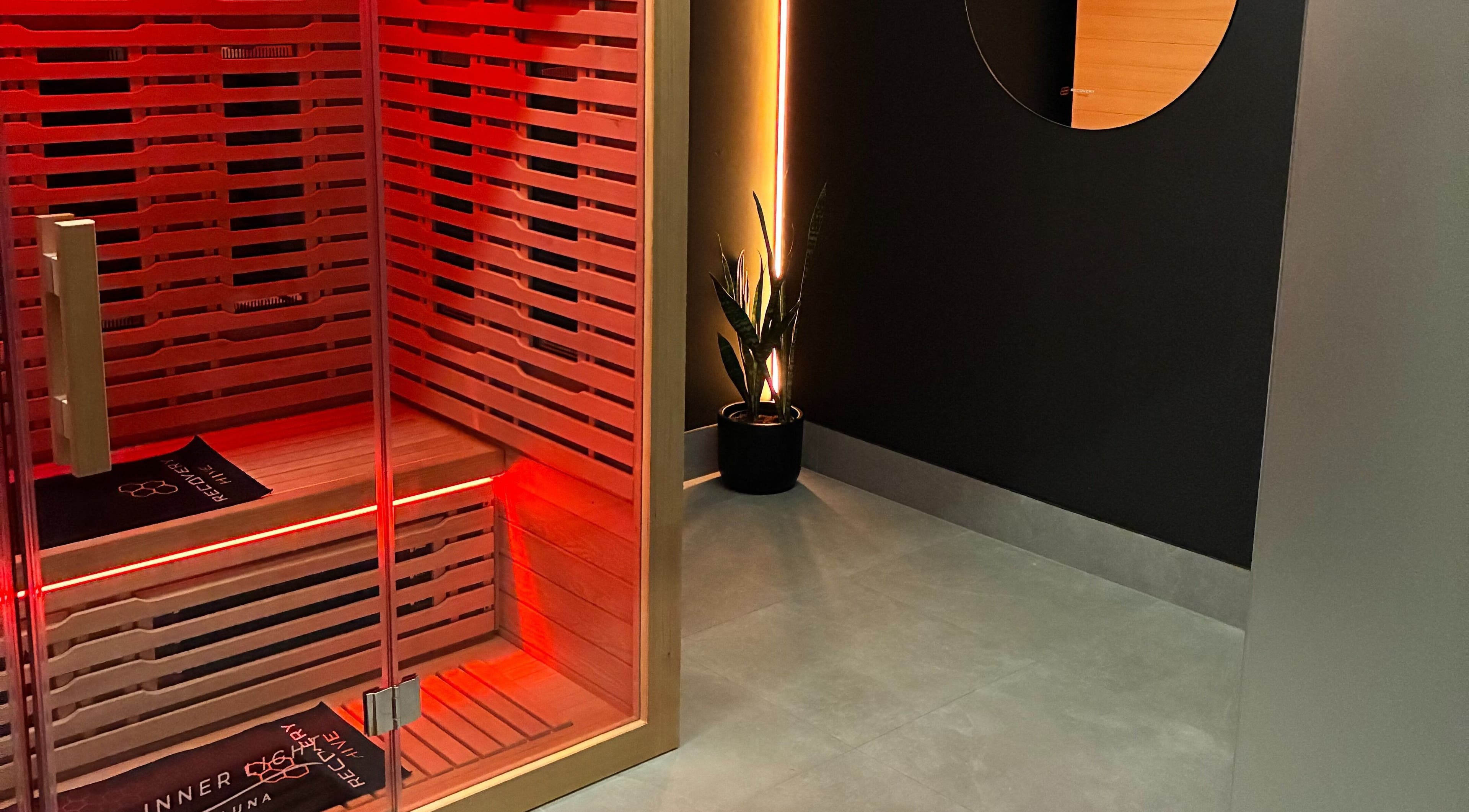 Red-lit sauna room at Recovery Hive, Coolum Beach, Queensland, AU offering relaxation and tranquility.