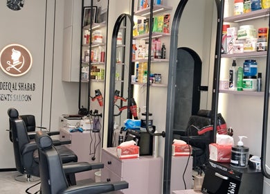 Elegant interior of Sadeeq Al Shabab Gents Saloon, Dubai, Dubai, AE with modern barber chairs and product shelves.