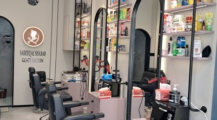 Elegant interior of Sadeeq Al Shabab Gents Saloon, Dubai, Dubai, AE with modern barber chairs and product shelves.