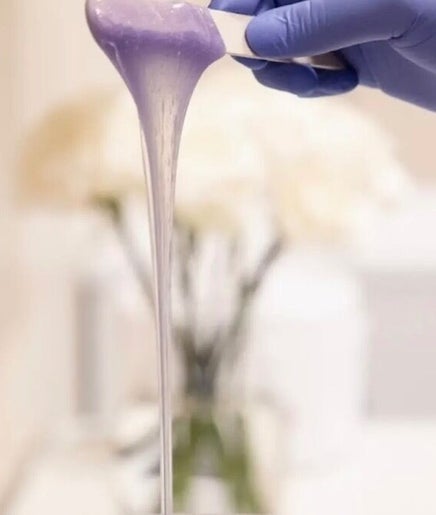 Purple wax being prepared at Luxe Wax & Facial Studio, Surrey, British Columbia, CA for a smooth waxing service.