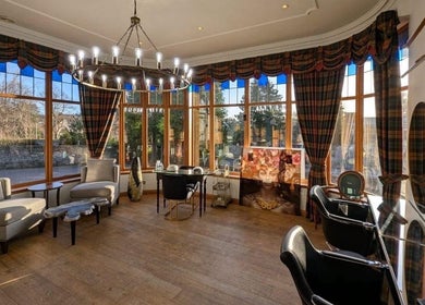 Elegant interior of Lovat Hair Nail and Beauty, Perth, Scotland, GB with plush seating and large windows.
