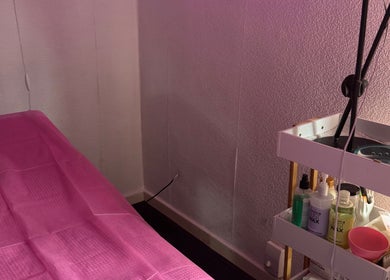 Tranquil treatment room at Deebeauty in Ashton-under-Lyne, England, GB with pink sheets and beauty products.