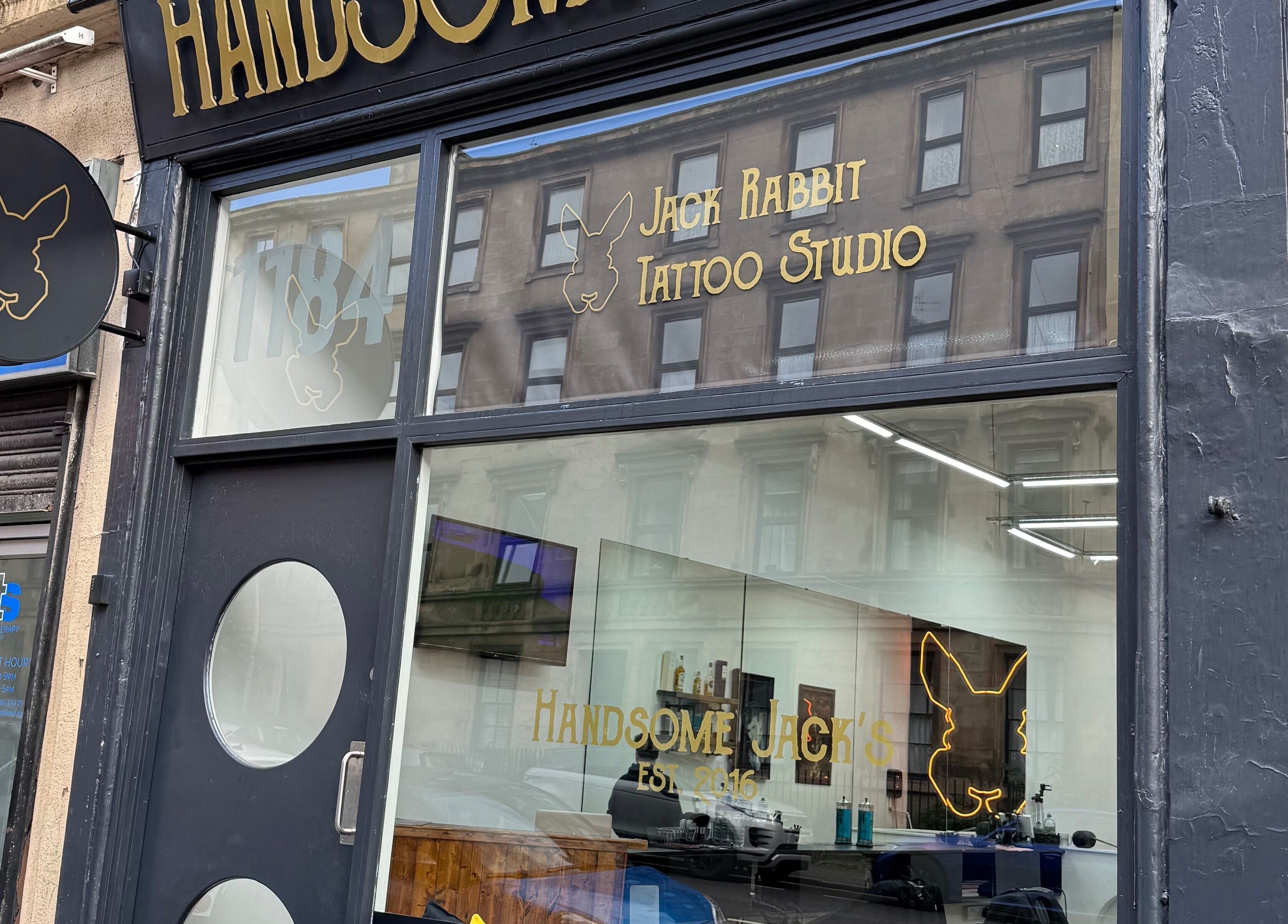 Exterior of Handsome Jacks Finnieston, a chic tattoo studio in Glasgow, Scotland, GB with modern signage.