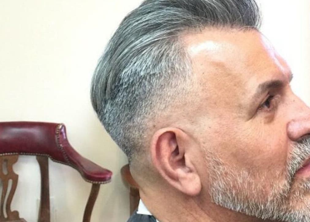 Moderne herenkapsel bij Joe Barbershop in Zwolle, Overijssel, NL. Traditionele stoel op de achtergrond.