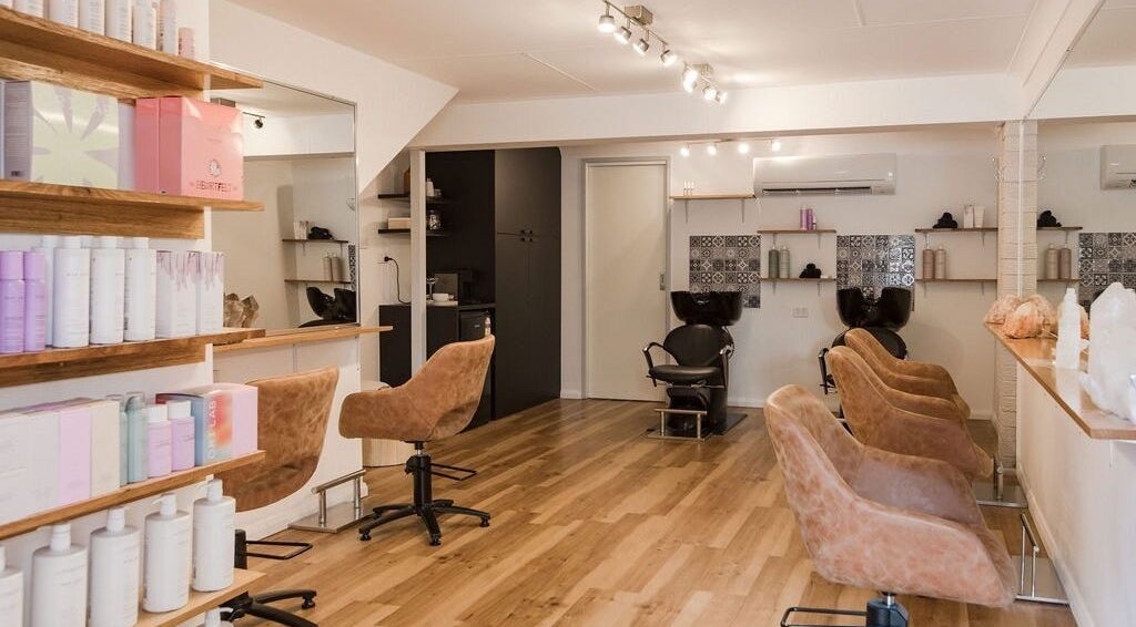 Interior of Alexander and Co Hair Studio in Wynnum, Queensland, AU, showcasing stylish seating and shelves.