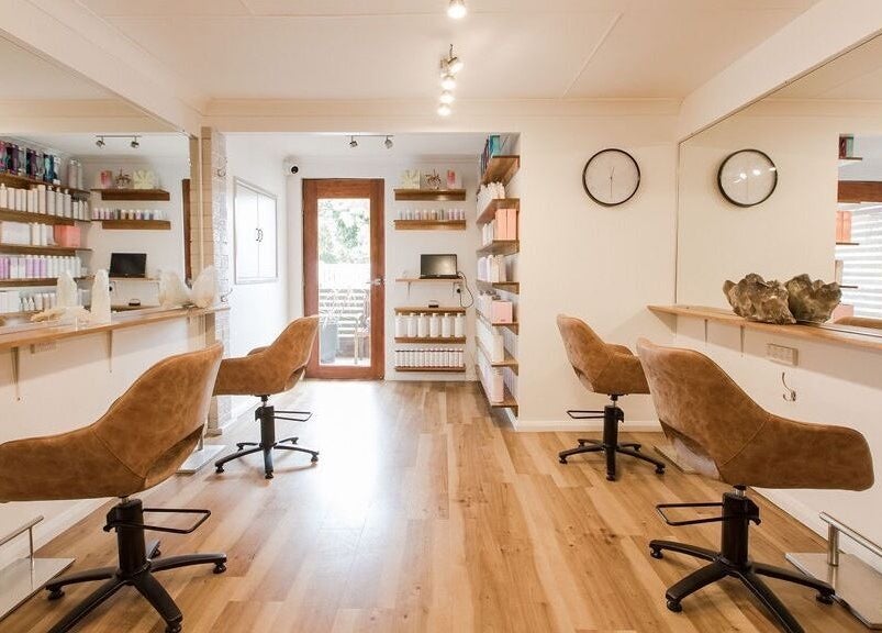 Stylish interior of Alexander and Co Hair Studio in Wynnum, Queensland, AU with modern chairs and product shelves.