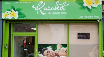 Entrance of Karaket Thai Massage in London, England, GB, with vibrant sign and inviting decor.