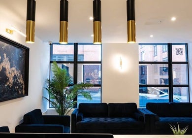 Stylish lounge area inside The Makeover Clinic, Birmingham, England, GB with modern decor and art.