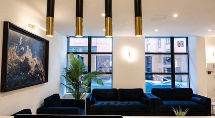Stylish lounge area inside The Makeover Clinic, Birmingham, England, GB with modern decor and art.