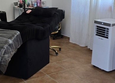 Sala de tratamento na Amabili da Rosa Nails, Oliveira De Frades, Viseu, PT, com sofá preto e ar-condicionado.
