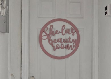 Entrance to She'la's beauty room in Hasland, England, GB with pink signage on a white door.