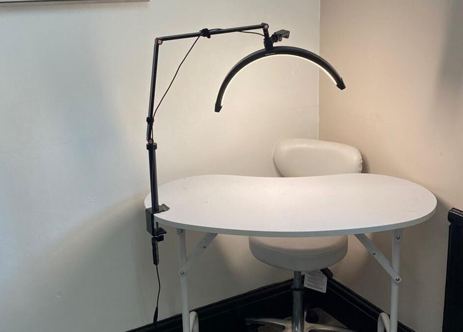 Compact manicure station at She'la's in Hasland, England, GB with modern lighting setup.