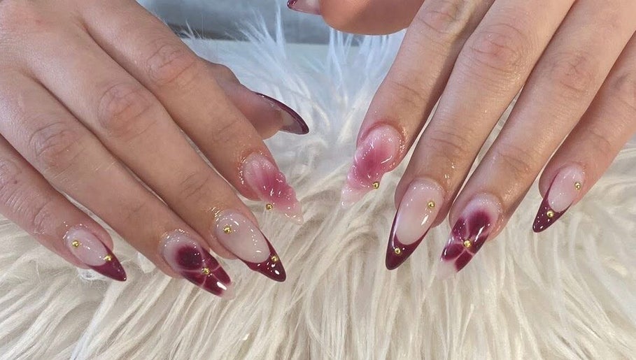 Stylish red and gold nail art at Adore Nail & Spa in Belmore, New South Wales, AU.