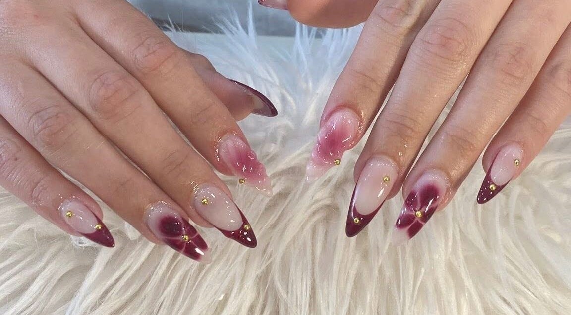 Stylish red and gold nail art at Adore Nail & Spa in Belmore, New South Wales, AU.