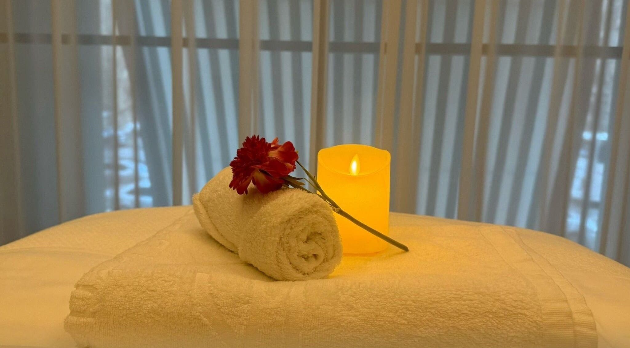 Relaxing spa setup with towel, candle, and flower at Swan Massage in Yuma, Arizona, US.