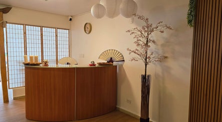 Recepción acogedora en Heiwa, Panamá, Provincia De Panamá con decoración japonesa y lámparas colgantes.