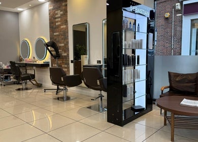 Modern interior of Hair Plus Southgate in London, England, GB with stylish seating and hair styling stations.