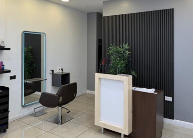 Modern salon interior at Hair Plus Southgate, London, England, GB, featuring stylish decor and hair styling station.