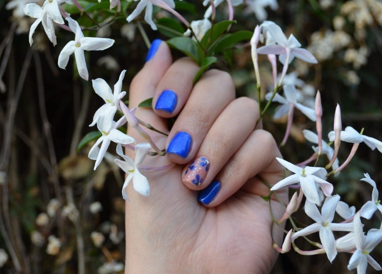 Elegant blue and floral nail design at The Tipsy Pixie, Roodepoort, Gauteng, ZA, surrounded by jasmine blooms.