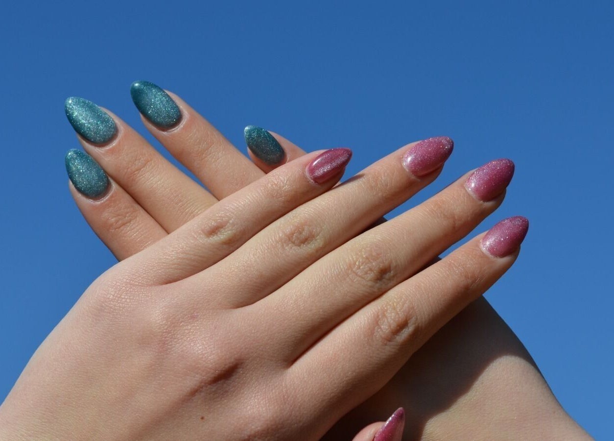 Stylish glitter nails in blue and pink at The Tipsy Pixie, Roodepoort, Gauteng, ZA against a clear sky.