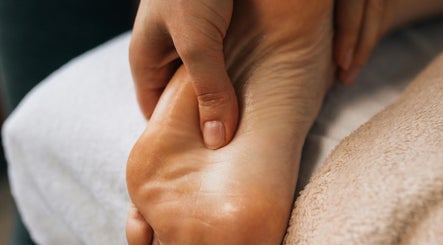 Reflexology session at Tychea Holistic & Wellness, Tampa, Florida, US. A hand massaging a foot for relaxation.