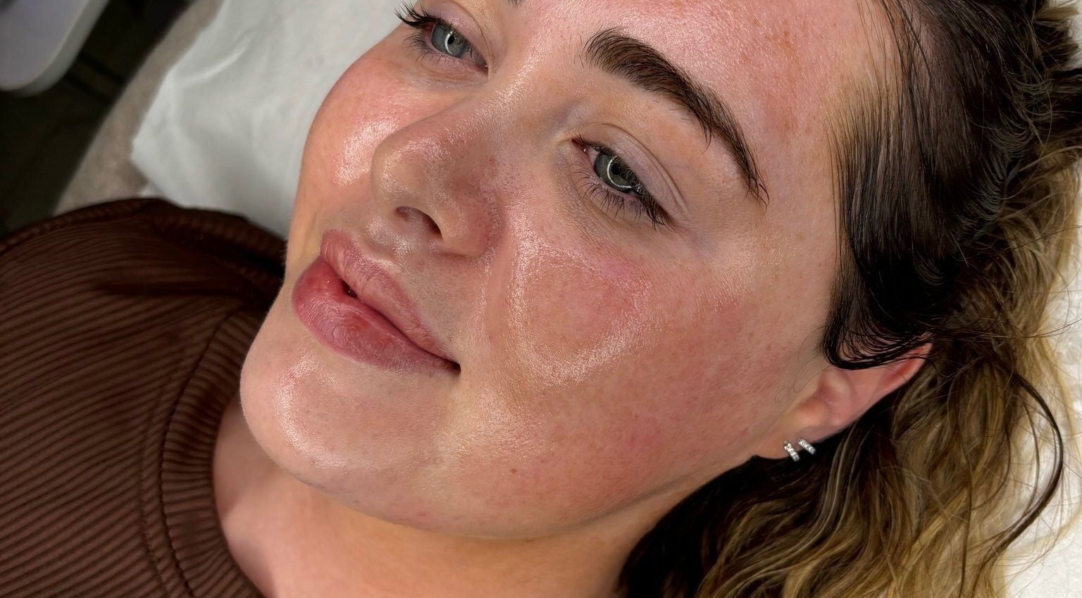 Client with glowing skin radiates after treatment at NA-E Skincare & Aesthetics, Northampton, England, GB.