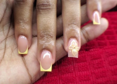 Stylish yellow French manicure with floral accent at NailsbyQ, Randburg, Gauteng, ZA.