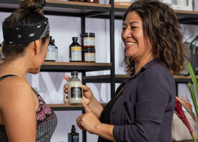 Profesional en PB for Women, Miraflores, Provincia De Lima, PE, mostrando producto de belleza a cliente.