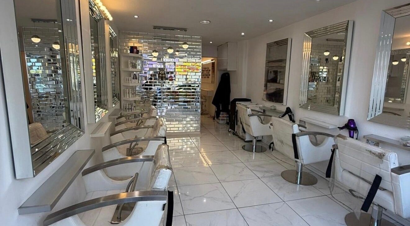 Chic interiors of HairbyBryanMurphy salon in Glasgow, Scotland, GB, highlighting modern styling chairs and mirrors.