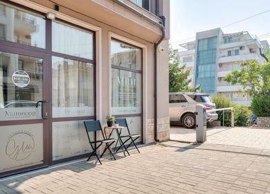 Entrance of Glow Nails & Academy in Бургас, Бургас, BG with chairs and plants outside.