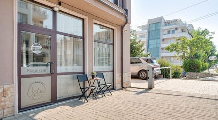Entrance of Glow Nails & Academy in Бургас, Бургас, BG with chairs and plants outside.