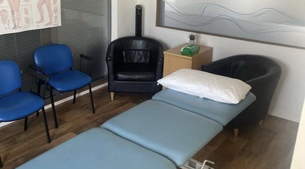 A tranquil massage room at CP Sports Massage Therapy, Kenfig Hill, Wales, GB, featuring cozy chairs and a massage bed.